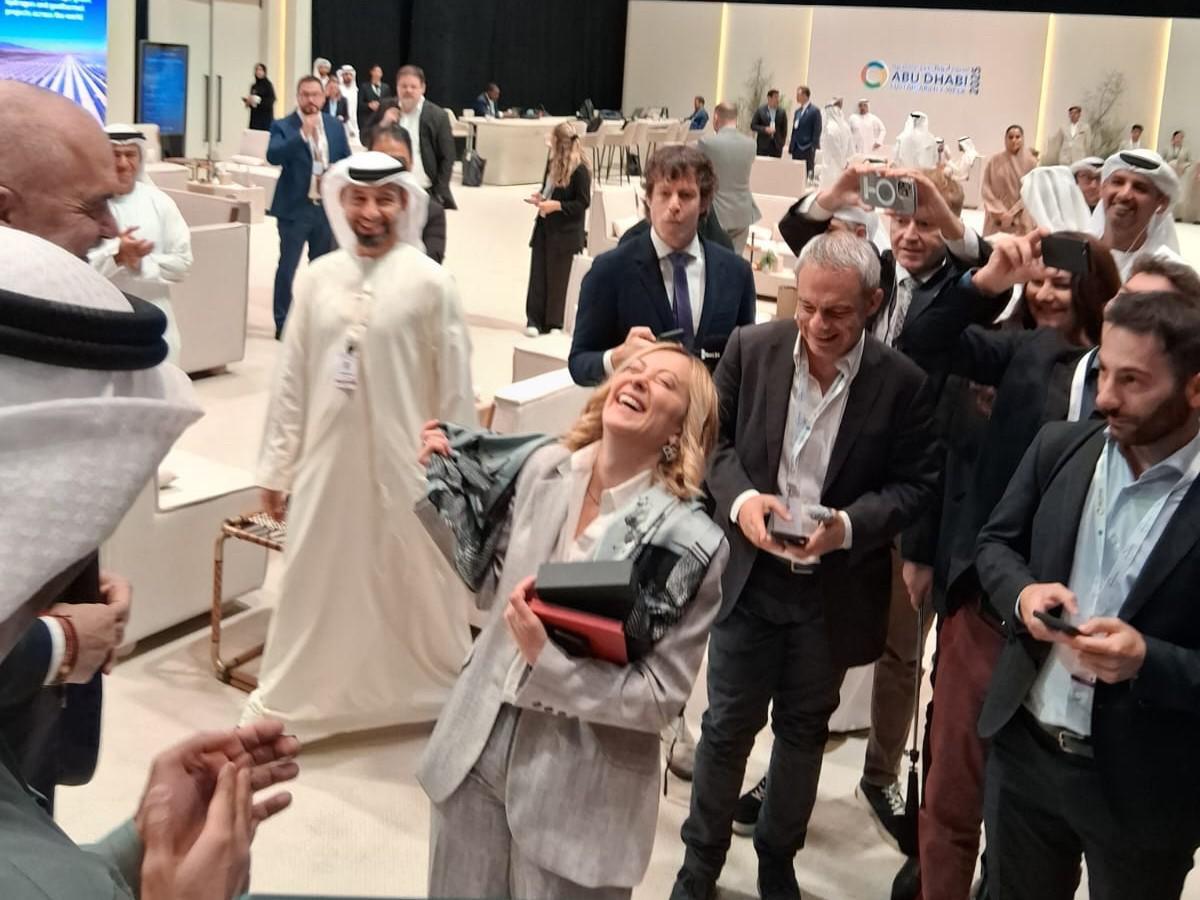 Rama si inginocchia davanti a Meloni e le regala un foulard durante il summit ad Abu Dhabi